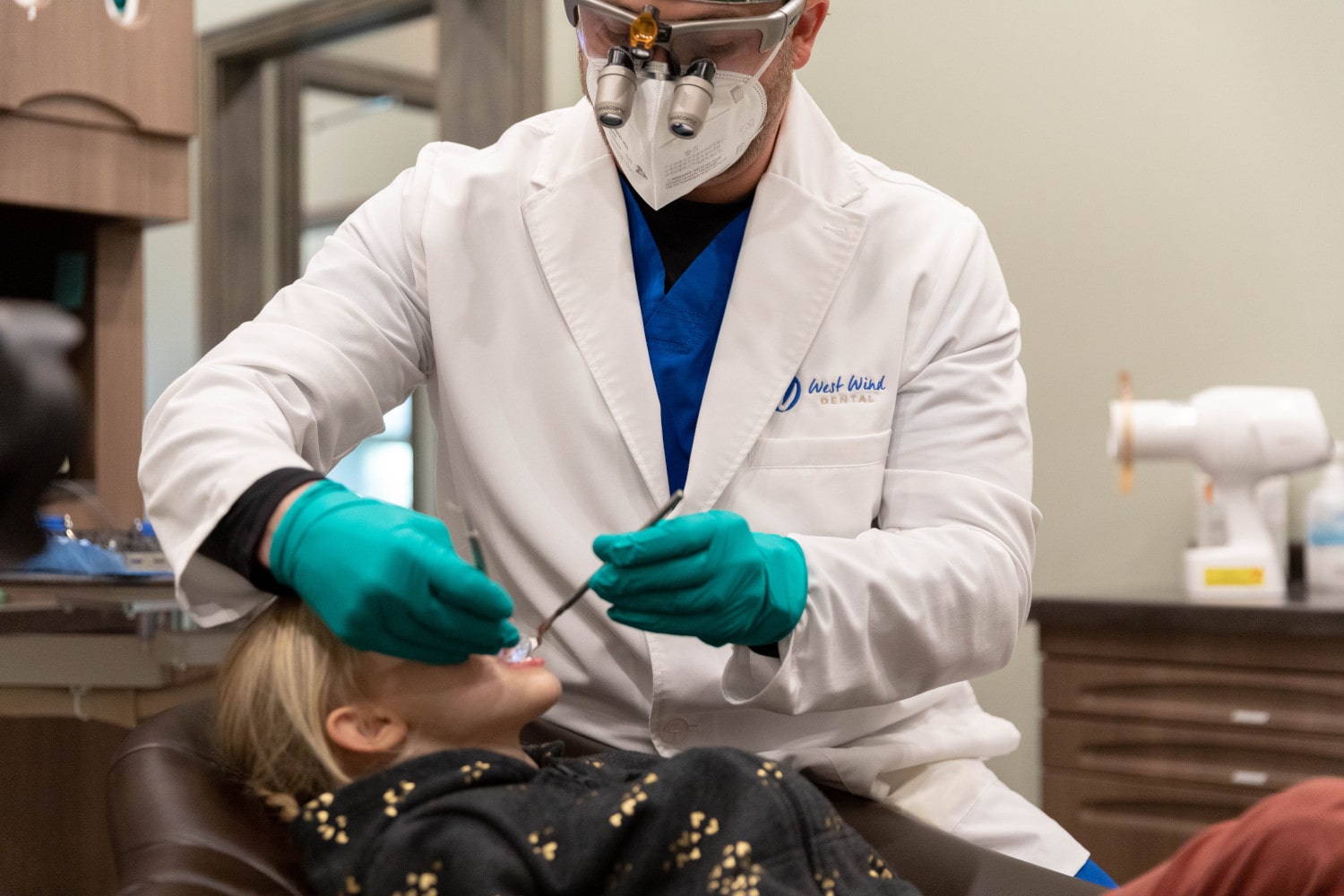 A female patient in a dental chair as the dentist works on her.